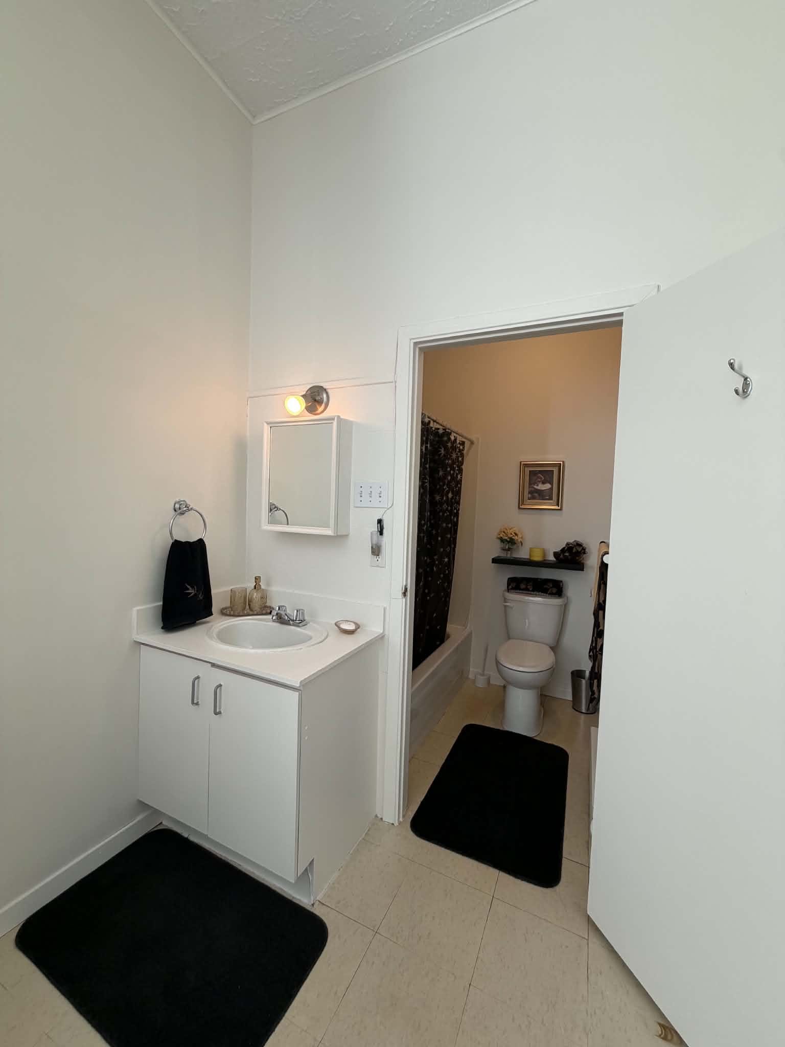 Salle de bain privée avec lavabo, miroir et bain-douche